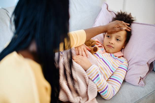 istock Sick child with high fever laying on sofa 1386866505