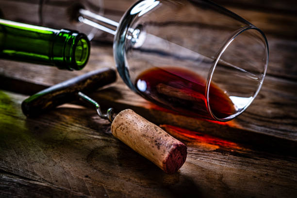 Red wine cork stopper, wineglass and wine bottle Rioja wine cork stopper, wineglass and wine bottle shot on rustic wooden table. High resolution 42Mp studio digital capture taken with SONY A7rII and Zeiss Batis 40mm F2.0 CF lens cork stopper stock pictures, royalty-free photos & images