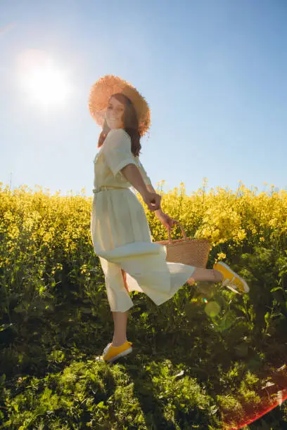 Photo of woman standing in rapeseed field