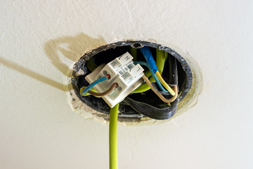 a hole in the ceiling with wiring for a chandelier. High quality photo