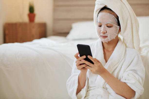 istock Woman In Bathrobe Texting Friends 1386870007