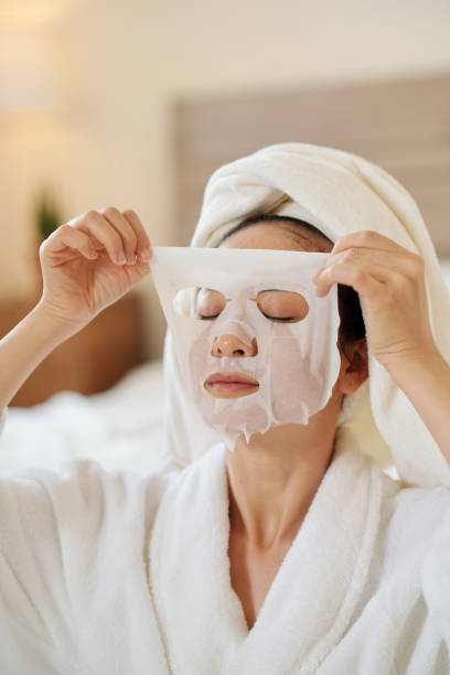 istock Woman Applying Cooling Sheet Mask 1386870012