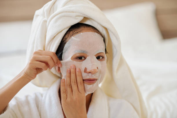 istock Woman Applying Enriched Face Mask 1386870015