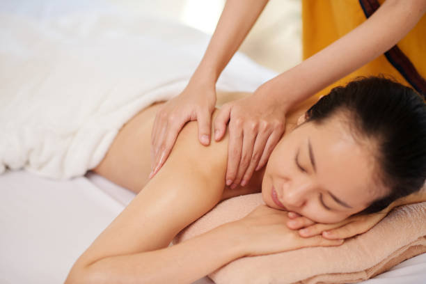 istock Masseur Massaging Back of Female Client 1386870016
