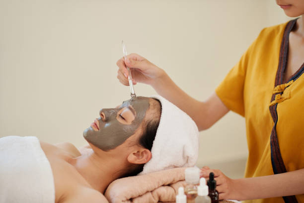 istock Beautician Applying Clay Mask 1386870049