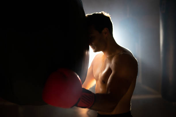 istock Tired boxer leaning on punching bag 1386870158