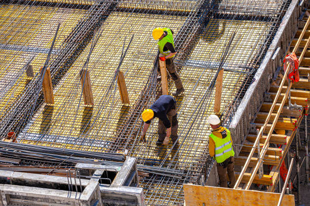 Workers make molds for reinforced concrete from reinforcing bars stock photo