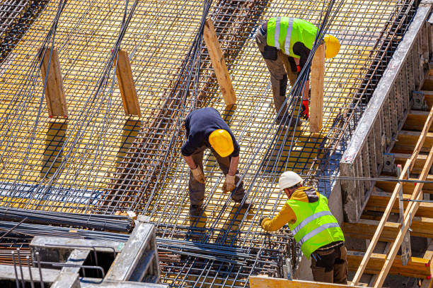 istock Workers make molds for reinforced concrete from reinforcing bars 1386874215