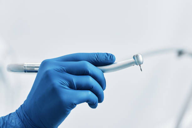 dentysta trzyma wiertło dentystyczne w klinice dentystycznej niebieskie rękawiczki lateksowe - dental drill zdjęcia i obrazy z banku zdjęć