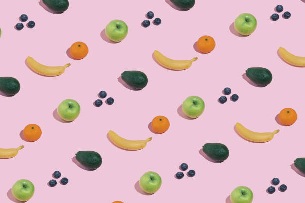 istock Modern minimal pattern with fruit, bananas, blueberries, apples, avocado and oranges on bright pink background. Trendy female healthy eating aesthetic. 1386875780