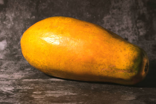 istock Ripe orange papaya isolated on a dark marbled background. 1386877450