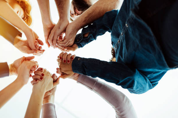 istock Multi ethnic and multi cultural group of young people holding their hands high 1386880311