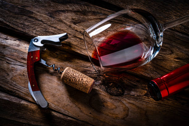 overhead view of a red wine bottle, cork stopper, corkscrew and wineglass - wine bottle wine wood bottle stopper imagens e fotografias de stock