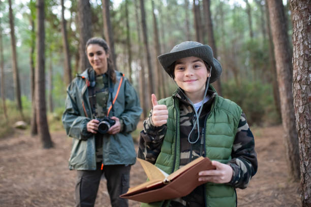istock Happy little boy with notebook in forest 1386881504