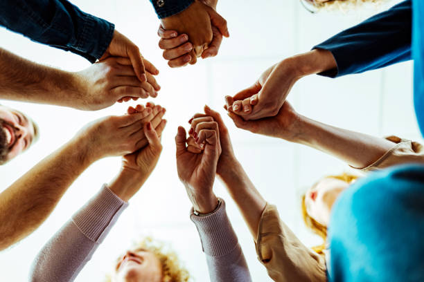 istock Group of people holding hands in unity 1386881681