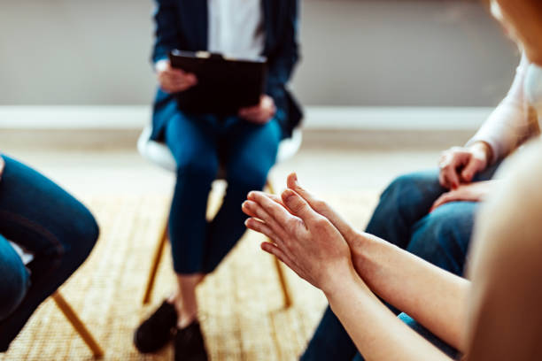 istock Unrecognizable woman in group therapy clasps hands 1386881833