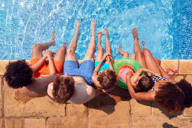 Overhead View Of Family With Children Having Fun In Swimming Pool On Summer Vacation stock photo