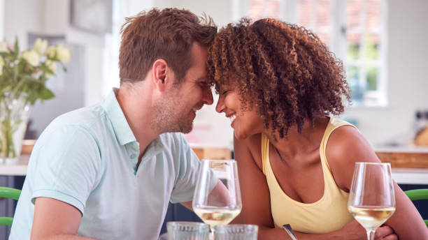 couple enjoying romantic meal at home on date night together - date night imagens e fotografias de stock