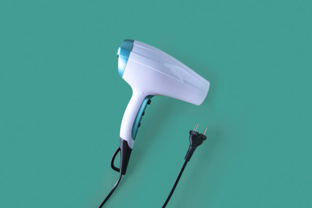 istock Eco-friendly ceramic ionic hairdryer  with styling tools on green background 1386883869