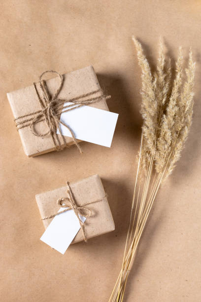 istock empty white gift tag mock up on craft paper box with dried spikelets decoration on natural beige background. 1386884064