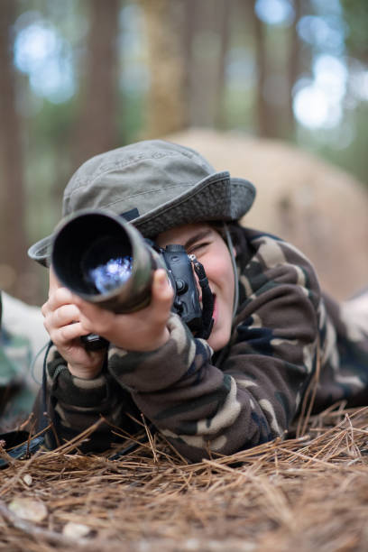 istock Happy boy taking pictures in forest 1386885433