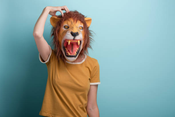 istock Young woman in lion mask thinking, scratching her head 1386885840