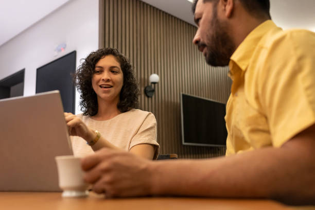istock Two Latino coworkers in a project meeting with notebook and coffee 1386885955