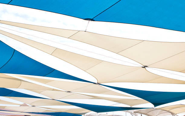 dreieckige leinwand, die die sonne schützt.; - shade sail awning textile stock-fotos und bilder
