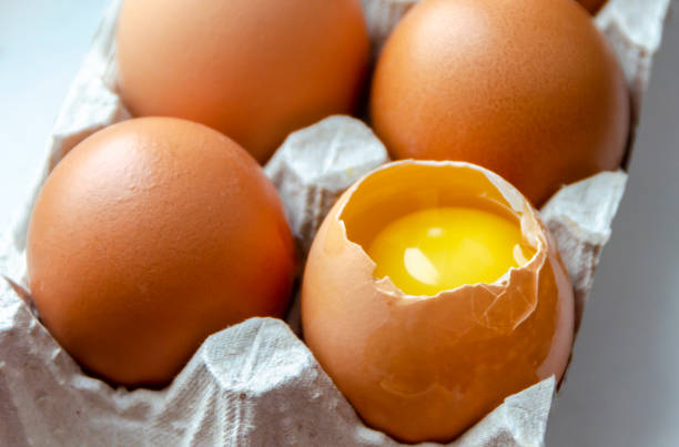 istock Raw chicken eggs and one broken in a cardboard box. 1386888636