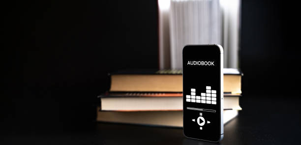 istock Audiobooks concept. Smartphone screen with audiobook application on paper books black background. Concept of education, library, students. 1386889163