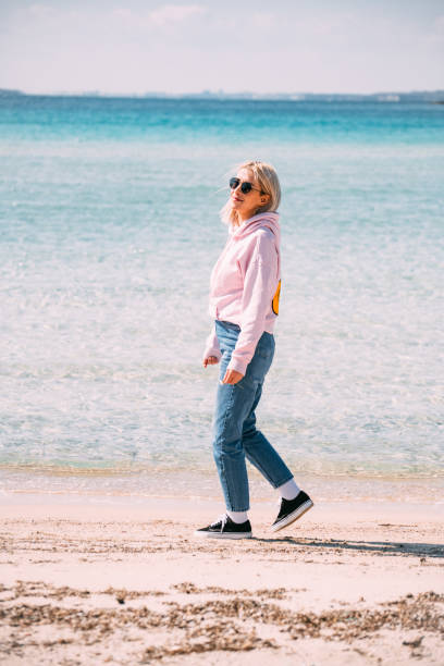 istock Blonde Woman Walking on the Beach 1386890237