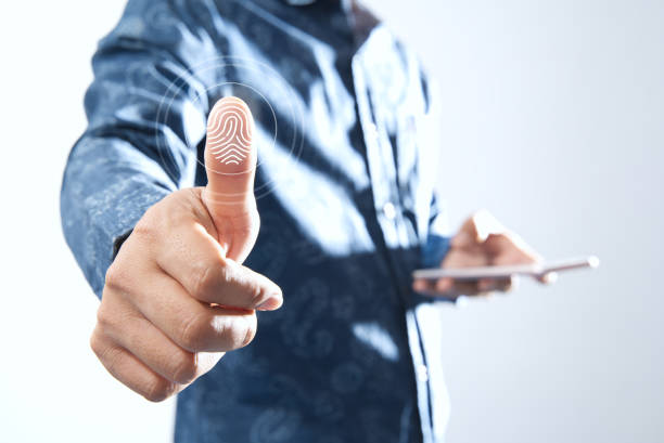 istock Man Shows Digital Processing Finger of the Future of Biometric Identification Fingerprint Scanner Personal Financial Data Access and digital program security scanning future cyber applications 1386890491