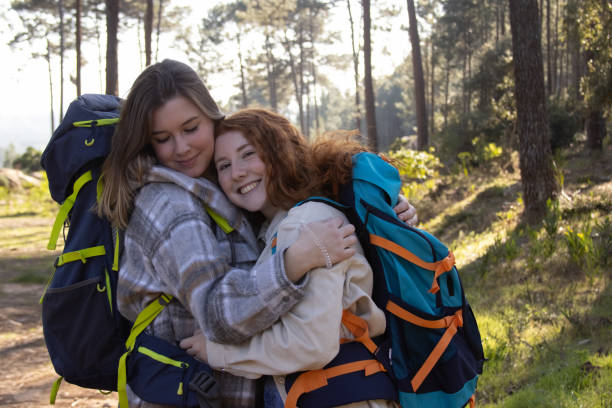 istock Portrait of two female backpackers embracing 1386890562
