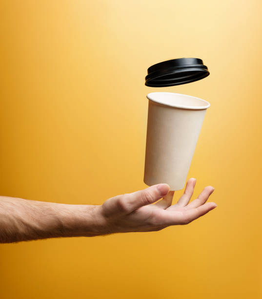 istock A paper glass for hot drinks levitates over a man's palm, close-up. 1386893980