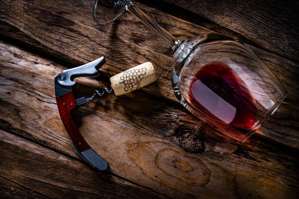 istock Red wine: cork stopper, corkscrew and wineglass on rustic wooden table 1386894071
