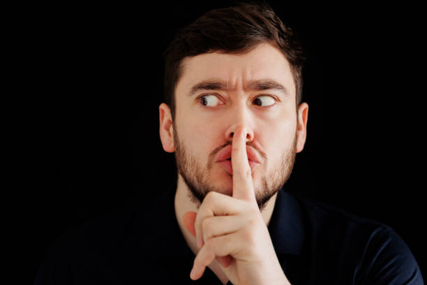 istock Mysterious bearded man putting finger on lips 1386894246