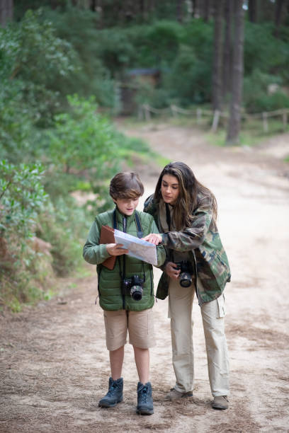 istock Active boy and woman with cameras walking in forest 1386894293