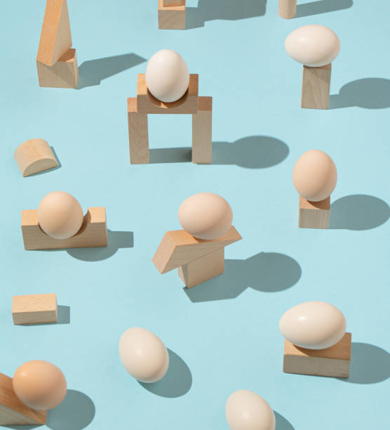 istock Trendy sunlight Summer pattern made with eggs and wooden geometric elements on bright light blue background. Minimal architectural concept. 1386894466