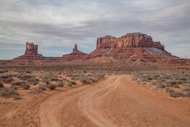 vista panoramica strada sterrata nella monument valley resa famosa dai film western - western usa foto e immagini stock