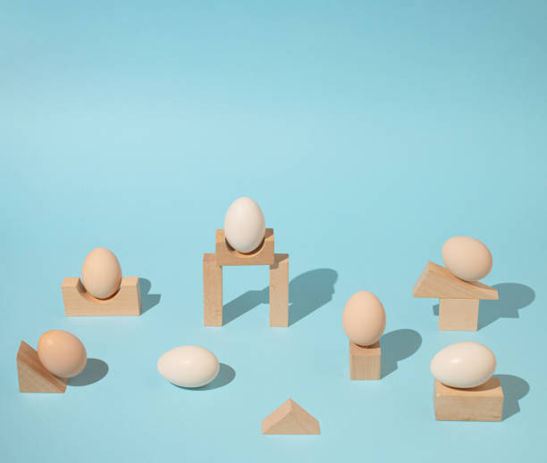 istock Trendy sunlight composition made with eggs and wooden geometric elements on bright light blue background. Minimal architectural concept. 1386896007