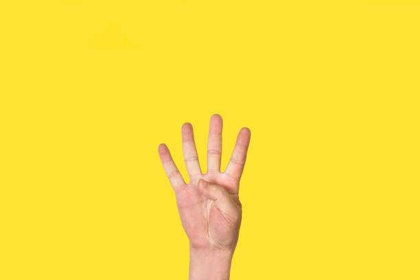 istock Man hand doing number four gesture on a yellow background 1386898062