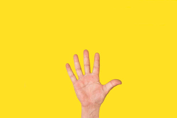 istock Man hand doing number five gesture on a yellow background 1386898573