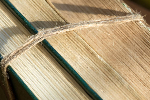 A stack of ancient books tied with twine. Close up photo