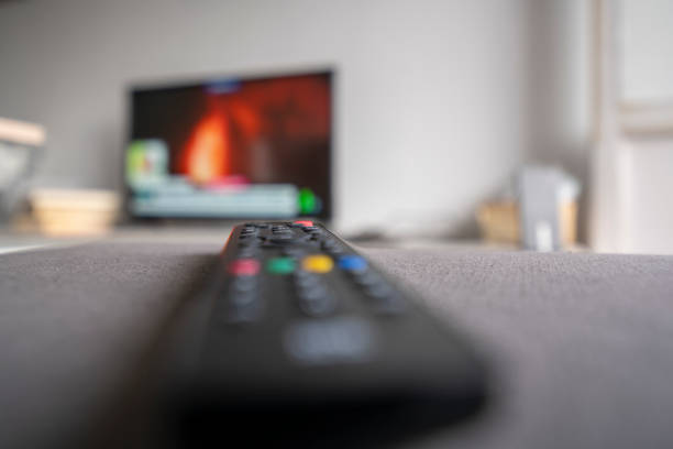 istock Television control on sofa with defocused television in background. 1386899117