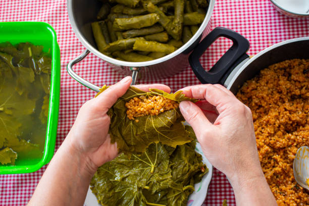 woman preparing stuffed grape leaves. - dolmades imagens e fotografias de stock