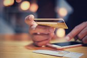 istock Man using credit card for online shopping payment with smartphone 1386900440
