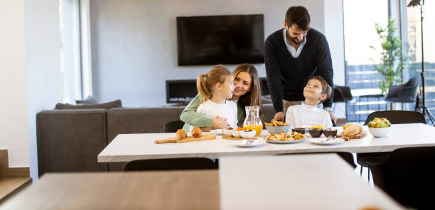 istock Young happy family talking while having breakfast at dining table 1386900560