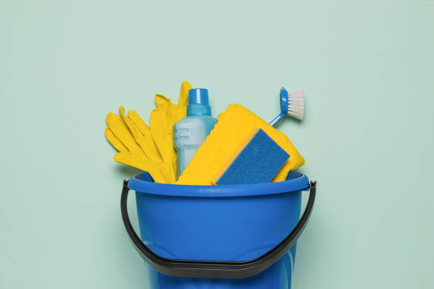 istock A blue bucket with a set of cleaning tools on a light background. Flat lay. 1386901826
