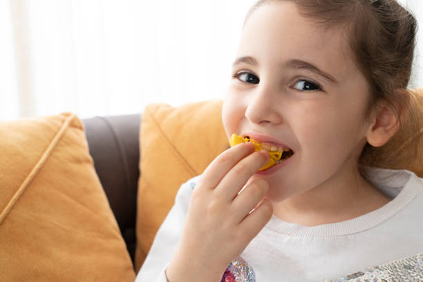 istock Little cute girl eating macaroons 1386902245