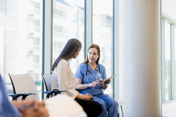 istock Female patient and nurse discuss her chart 1386902461